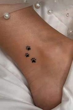 a woman's foot with two paw prints on the side of her left ankle