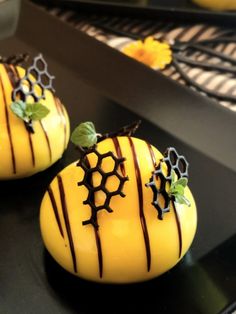 two yellow desserts with chocolate drizzled on them sitting on a counter