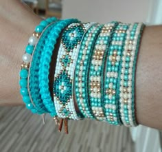 a woman's arm with several bracelets on top of it and beads around the wrist