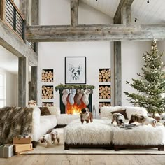 a living room filled with furniture and a fire place covered in stockings next to a christmas tree