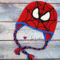 a crocheted spiderman hat on top of a wooden table