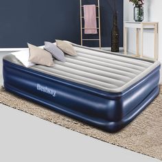 an inflatable bed with pillows on the top and bottom is sitting on a carpeted floor