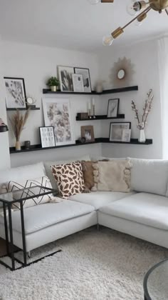 a living room filled with lots of furniture and pictures on the wall above it's shelves