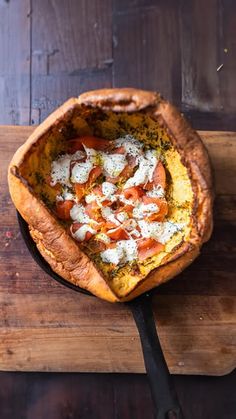 a pizza sitting on top of a wooden cutting board