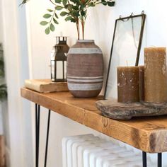 some candles are sitting on a shelf next to a potted plant and a mirror