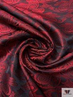 a red and black paisley print fabric with an intricate design on the bottom half of it