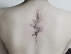 the back of a woman's shoulder with a flower tattoo on her left side