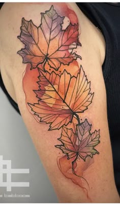 a woman's arm with leaves on it and watercolors in the background