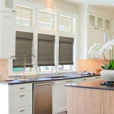 a kitchen with white cabinets and black counter tops