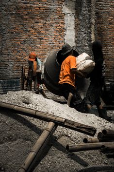 two men are working on a construction project in an old brick walled area with wood and cement