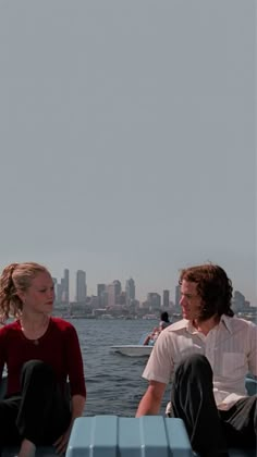 a man and woman sitting on the back of a boat