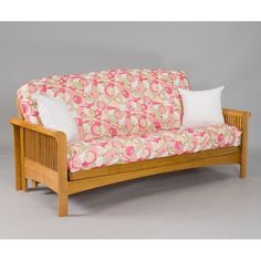 a wooden futon with pink and green floral fabric on it, against a gray background