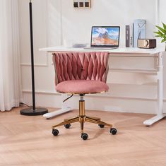 a pink office chair sitting in front of a white desk