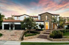 a house with steps leading up to the front door and landscaping in front of it