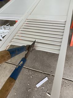 a pair of pliers cutting through the side of a window with slats on it