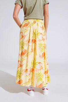 Brighten up your wardrobe with our Yellow Maxi Skirt with Tropical Print. Made from 100% viscose, this skirt offers a very light and soft feel, ensuring comfort and style throughout the day. The skirt features a vibrant tropical flower print that adds a touch of paradise to your look. With a relaxed fit and maxi length, it flows beautifully with every step. The elastic waist and side pockets provide both convenience and a perfect fit. Key Features: Material: 100% Viscose Fit: Runs true to size, relaxed fit Details: Maxi length, floral print, elastic waist, side pockets, lightweight woven fabric Model Info: Wearing size S. Measurements - Bust: 29", Waist: 25", Hips: 35", Height: 5'11" Perfect for daily wear, this skirt can be paired with a simple top and sandals for a chic summer look. Embr