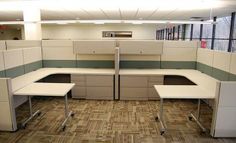 an office cubicle with two desks and one chair in the middle is empty