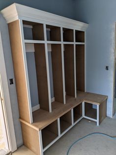 a room that has some shelves and cabinets in it, with no doors on the wall