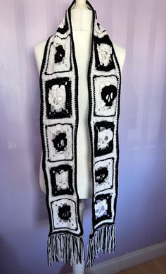 a black and white crocheted scarf on a mannequin