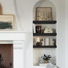 a living room filled with furniture and a fire place in front of a white fireplace