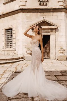 a woman in a wedding dress is posing for the camera with her hand on her head