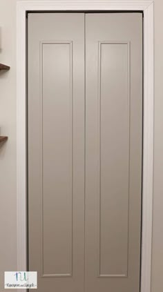 a white door with two brown shelves on the wall and a light fixture above it