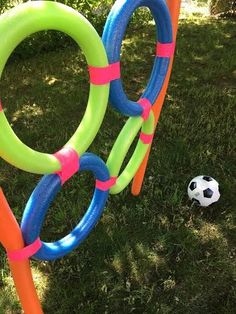 an inflatable soccer ball is next to some rings on the grass