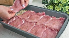 someone is cutting meat into pieces in a pan