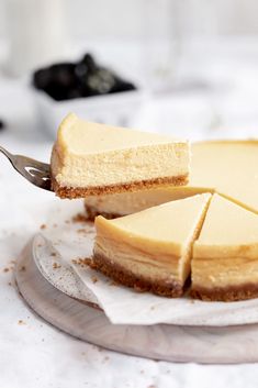 a piece of cheesecake on a plate with a knife stuck in the top slice