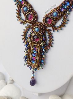 the necklace is adorned with multicolored beads and bead work on it's neck