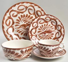 an ornately decorated dinnerware set with matching saucers and cups is displayed on a white background