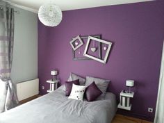 a bedroom with purple walls and pictures on the wall above the bed, along with two nightstands