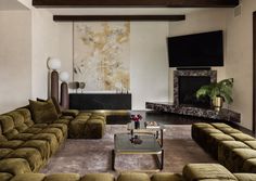 a living room filled with furniture and a flat screen tv mounted on the wall over a fireplace