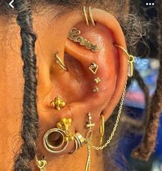 a woman with ear piercings on her ears and behind the ear is a gold chain