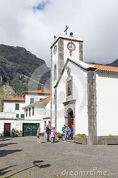 people are walking around in front of an old church