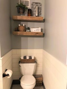 a white toilet sitting in a bathroom next to two shelves