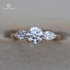 a three stone ring with two pear shaped diamonds