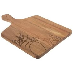 a wooden cutting board with pumpkins and leaves on the bottom, engraved in black ink