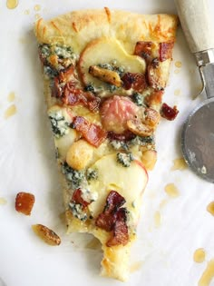 a slice of pizza with bacon and spinach on it next to a spatula