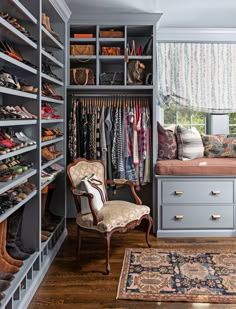 a walk in closet filled with lots of shoes and other items, including a chair