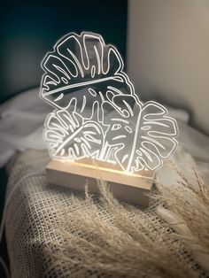 a light that is sitting on top of a table next to some grass and plants