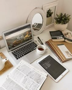 an open laptop computer sitting on top of a desk next to a cup of coffee