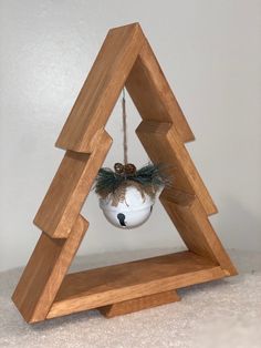 a christmas ornament hanging from a wooden triangle