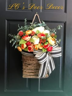 a door hanger decorated with flowers and ribbon hangs on the front door's black door