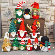 crocheted christmas gnomes and santa hats on display in front of a fireplace