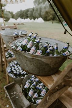 several buckets filled with beer sitting on top of a wooden table