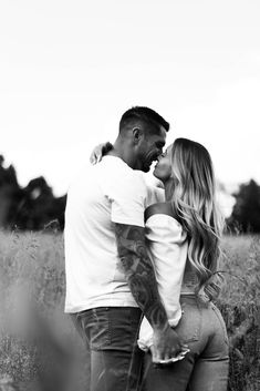 a man and woman standing next to each other in a field