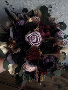 a bridal bouquet made up of flowers and feathers