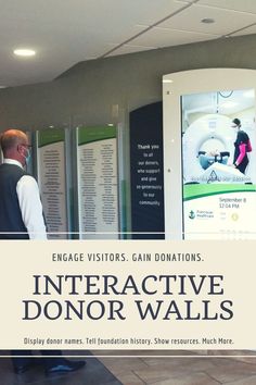 a man standing in front of an interactive donor wall