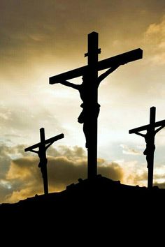 the silhouette of three crucifixs on top of a hill at sunset